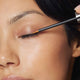 Image of Asian woman applying Yep Lash XL eyelash serum to the upper eyelid - Transform your lashes today!