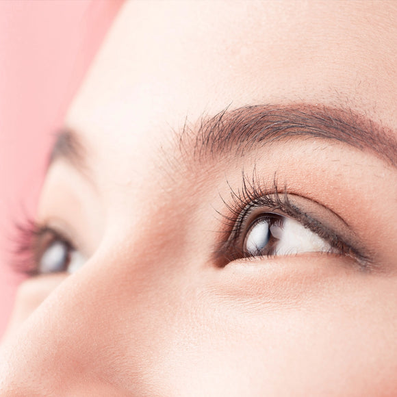 Close up of an Asian woman with short eyelashes. Her eyelashes highlight her eyes with a delicate look.