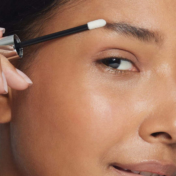 Image of African American woman applying eyebrow serum - Apply daily to achieve bold and beautiful brows!