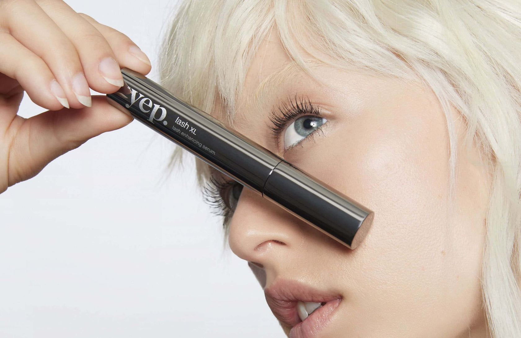 A woman holding an eyelash serum that enhanced her lashes with a fuller, more voluminous look.